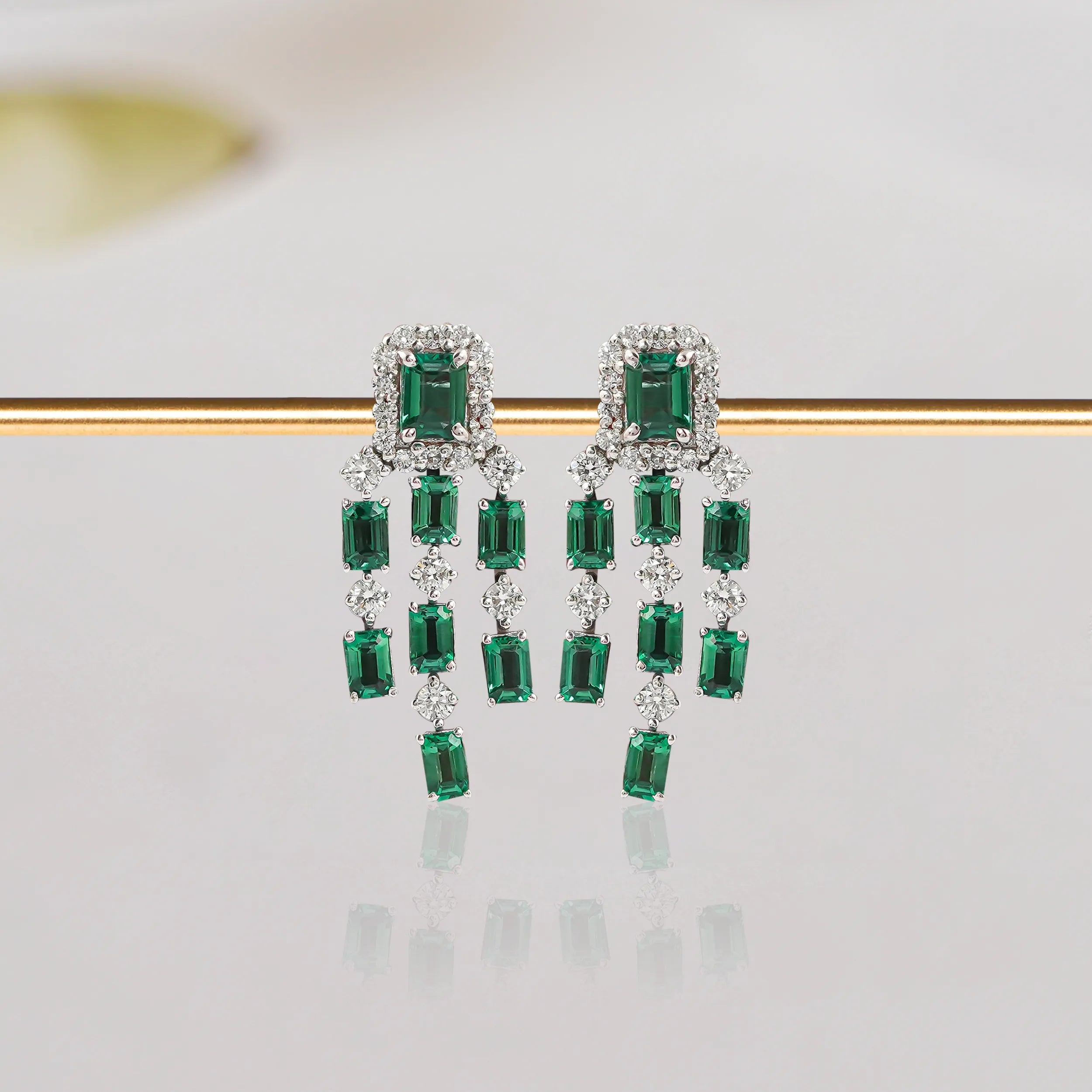 Image displaying green baguette gemstone and diamond chandelier earrings