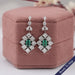Green Emerald And Princess Diamond Halo Earrings Earrings